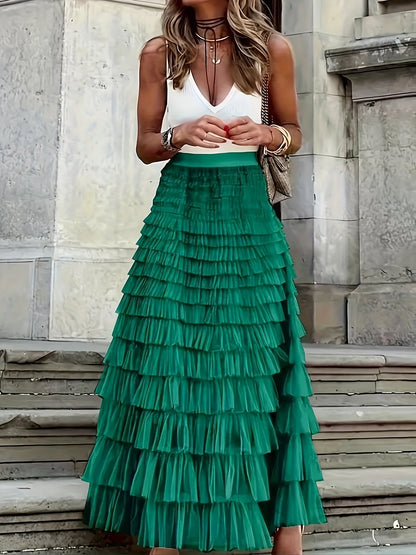 Woman wearing the Sophie Women's Layered Tulle Skirt, a ruffled skirt with multiple soft layers, creating a flowing and voluminous look, styled with a sleeveless top and accessories, standing on steps outdoors.