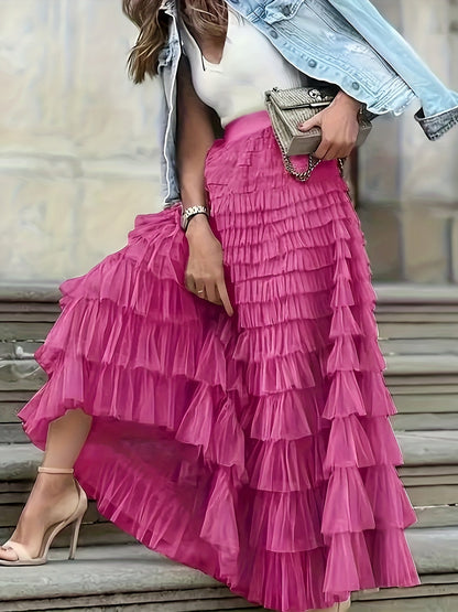 Woman wearing the Sophie Women's Layered Tulle Skirt, a ruffled skirt with multiple soft layers, creating a flowing and voluminous look, styled with a sleeveless top and accessories, standing on steps outdoors.