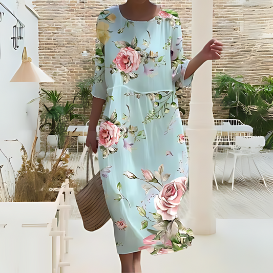 Elegant women's floral dress worn on the beach, paired with a woven handbag, perfect for summer outings and casual strolls.