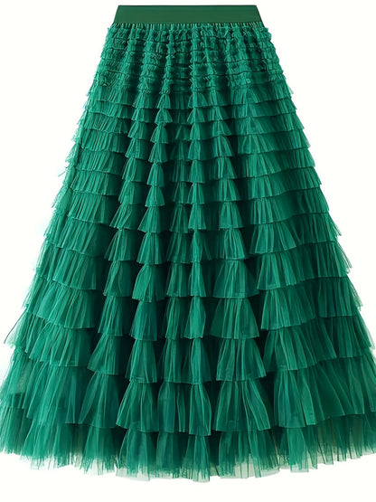 Woman wearing the Sophie Women's Layered Tulle Skirt, a ruffled skirt with multiple soft layers, creating a flowing and voluminous look, styled with a sleeveless top and accessories, standing on steps outdoors.