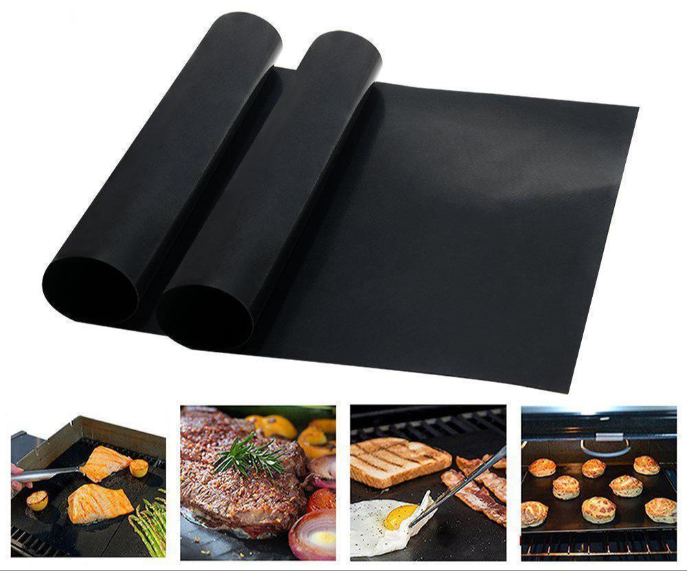 Non-stick grill mat placed on a barbecue grill with grilled salmon fillets and lemon slices, showcasing even cooking and ease of use.