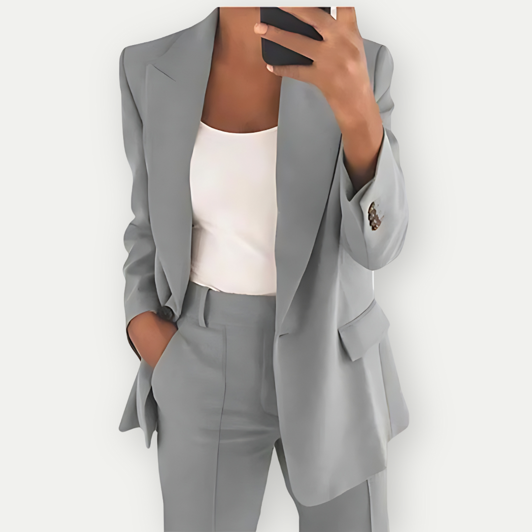 Woman wearing the Samantha Women's Tailored Blazer Set, featuring a fitted blazer with notch lapels and matching tailored pants, paired with a simple top, showcasing a chic and polished look perfect for both professional and casual occasions.