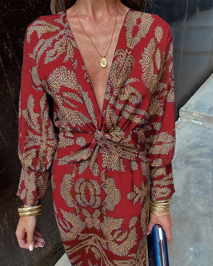 A close-up of a woman wearing the Nina Women's Elegant Wrap Dress, featuring a bold pattern and flattering wrap design with a deep V-neckline. The dress showcases intricate patterns and a knot detail at the waist, creating a sophisticated and stylish look suitable for special occasions.