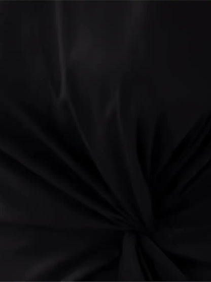 A woman wearing an elegant dress with a flattering ruched design, perfect for both casual outings and formal events. The dress highlights a sophisticated and stylish silhouette, paired with a clutch for a polished look.
