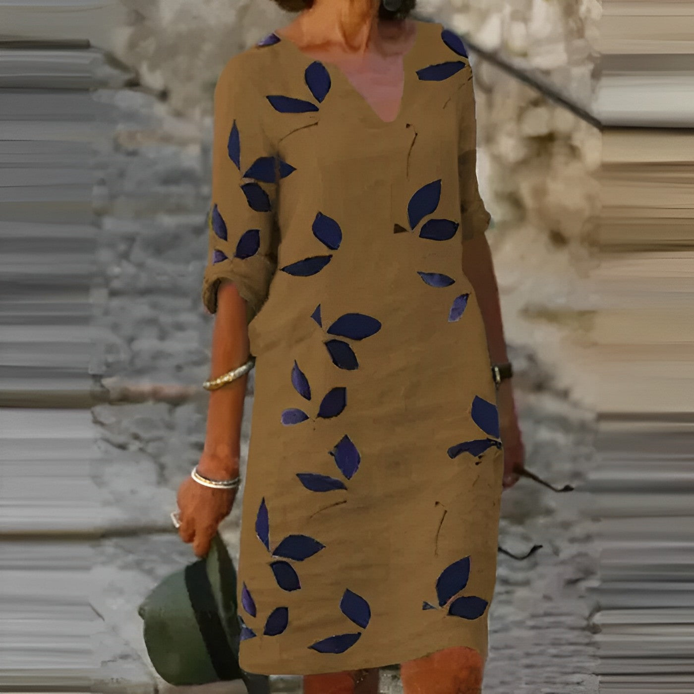 A woman wearing the Sophie Women's Leaf Print Shift Dress with an elegant V-neckline and a stylish leaf pattern. This dress features a relaxed, comfortable fit, ideal for casual or semi-formal occasions, offering a chic and nature-inspired look.