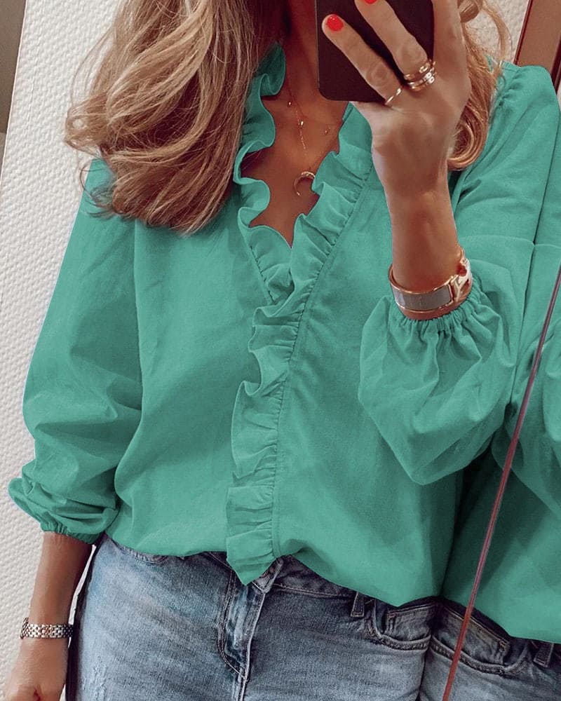 Model wearing the Clara Women's Ruffled Blouse, featuring elegant ruffle detailing and a sophisticated design, paired with casual jeans for a chic look.