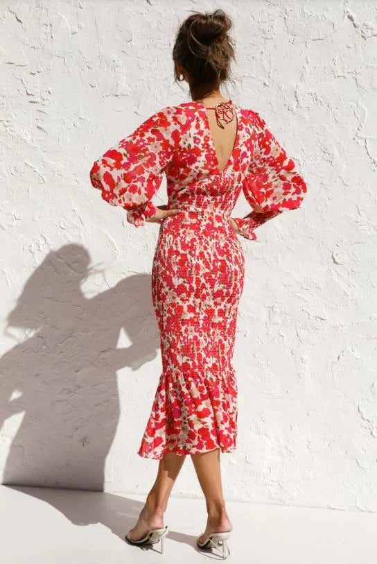 A stylish woman wearing the Emma | Women's Backless Midi Dress | Elegant Floral Dress, showcasing its elegant backless design and flattering midi length. The dress features long sleeves and a fitted waist, creating a sophisticated and graceful look.