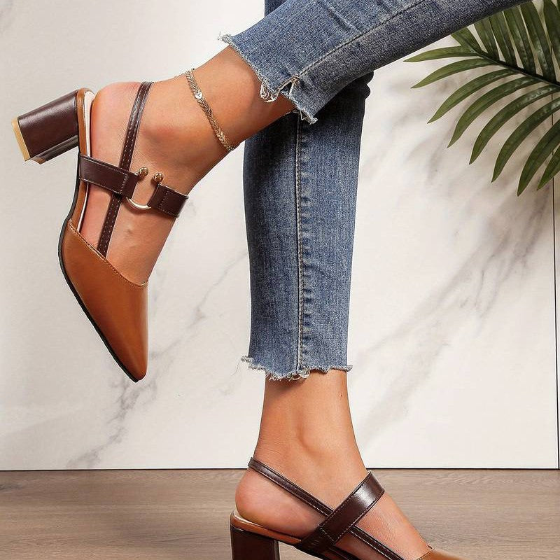  A pair of Sophia Women's Elegant Block Heel Shoes with a stylish double-strap design and pointed toe, worn by a person. These heels feature a comfortable block heel, perfect for adding elegance to both casual and formal outfits.