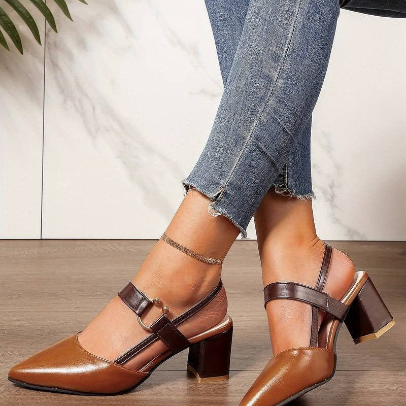  A pair of Sophia Women's Elegant Block Heel Shoes with a stylish double-strap design and pointed toe, worn by a person. These heels feature a comfortable block heel, perfect for adding elegance to both casual and formal outfits.