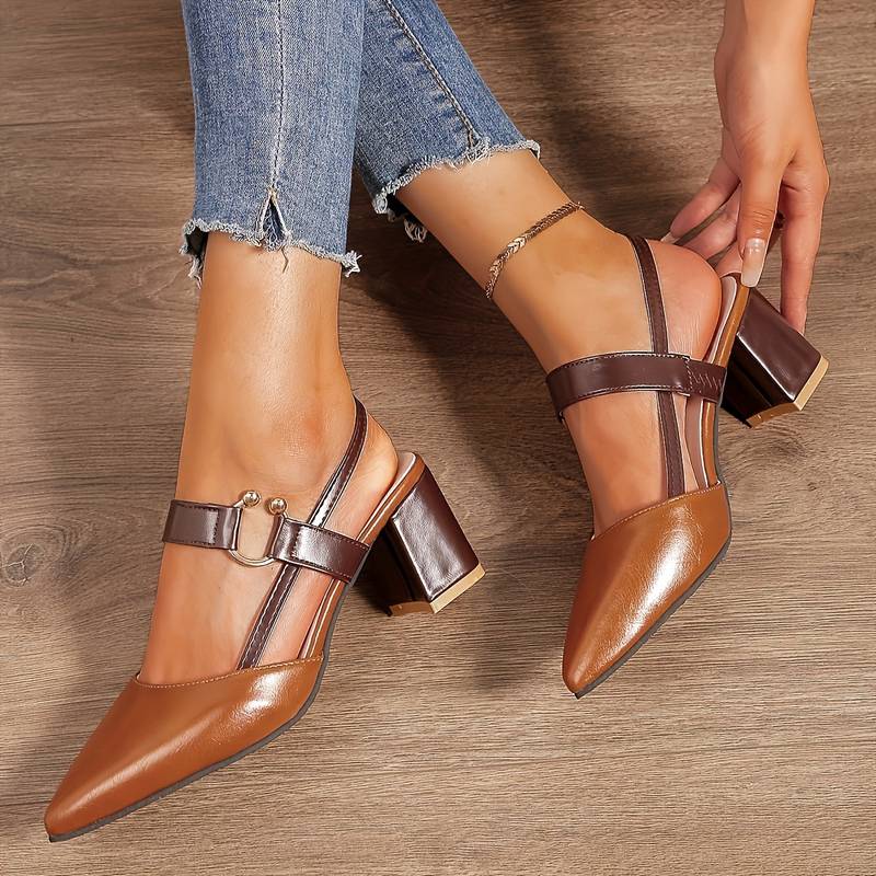  A pair of Sophia Women's Elegant Block Heel Shoes with a stylish double-strap design and pointed toe, worn by a person. These heels feature a comfortable block heel, perfect for adding elegance to both casual and formal outfits.