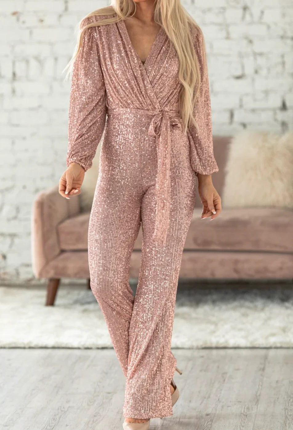 Model wearing the Isabella | Glamorous Sequin Jumpsuit, featuring a wrap-style top, long sleeves, and a wide-leg cut adorned with sparkling sequins. Perfect for special occasions, this jumpsuit combines elegance and comfort for a bold, statement-making look.