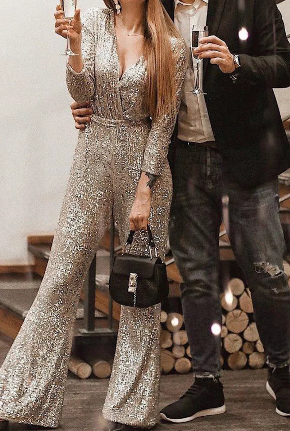 Model wearing the Isabella | Glamorous Sequin Jumpsuit, featuring a wrap-style top, long sleeves, and a wide-leg cut adorned with sparkling sequins. Perfect for special occasions, this jumpsuit combines elegance and comfort for a bold, statement-making look.