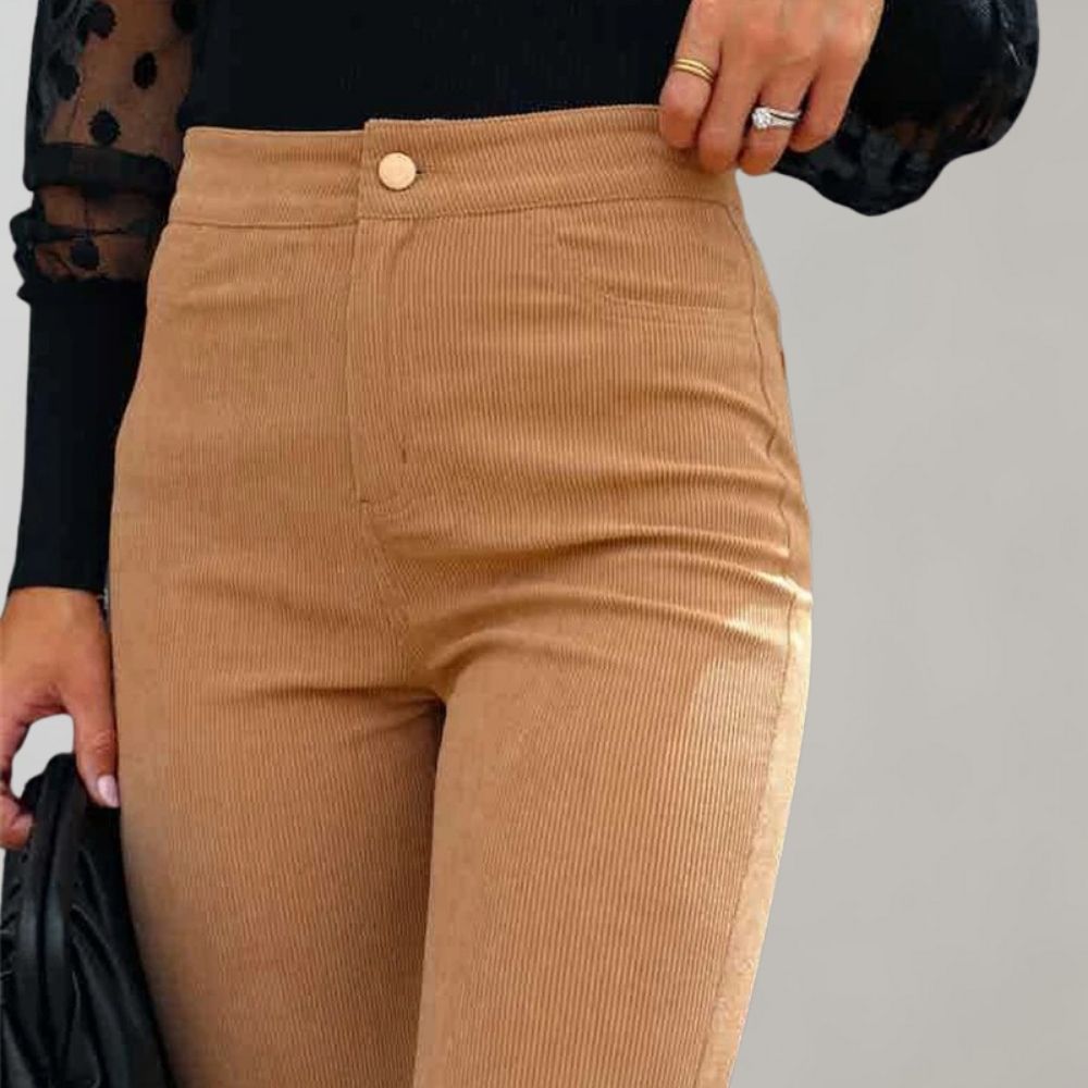 A woman modeling high-waisted flared pants paired with a cropped knit top and a stylish handbag, showcasing the chic and versatile design of the Lila | Women's High-Waisted Flared Pants | Chic Corduroy Trousers.