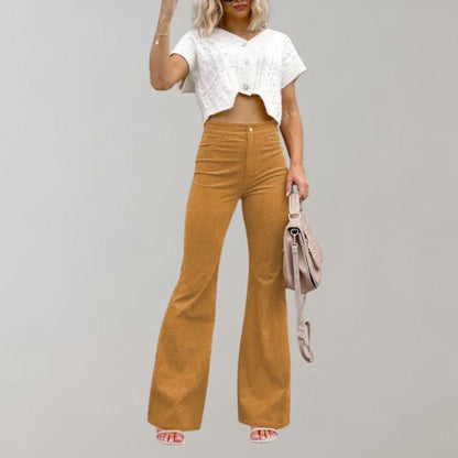 A woman modeling high-waisted flared pants paired with a cropped knit top and a stylish handbag, showcasing the chic and versatile design of the Lila | Women's High-Waisted Flared Pants | Chic Corduroy Trousers.