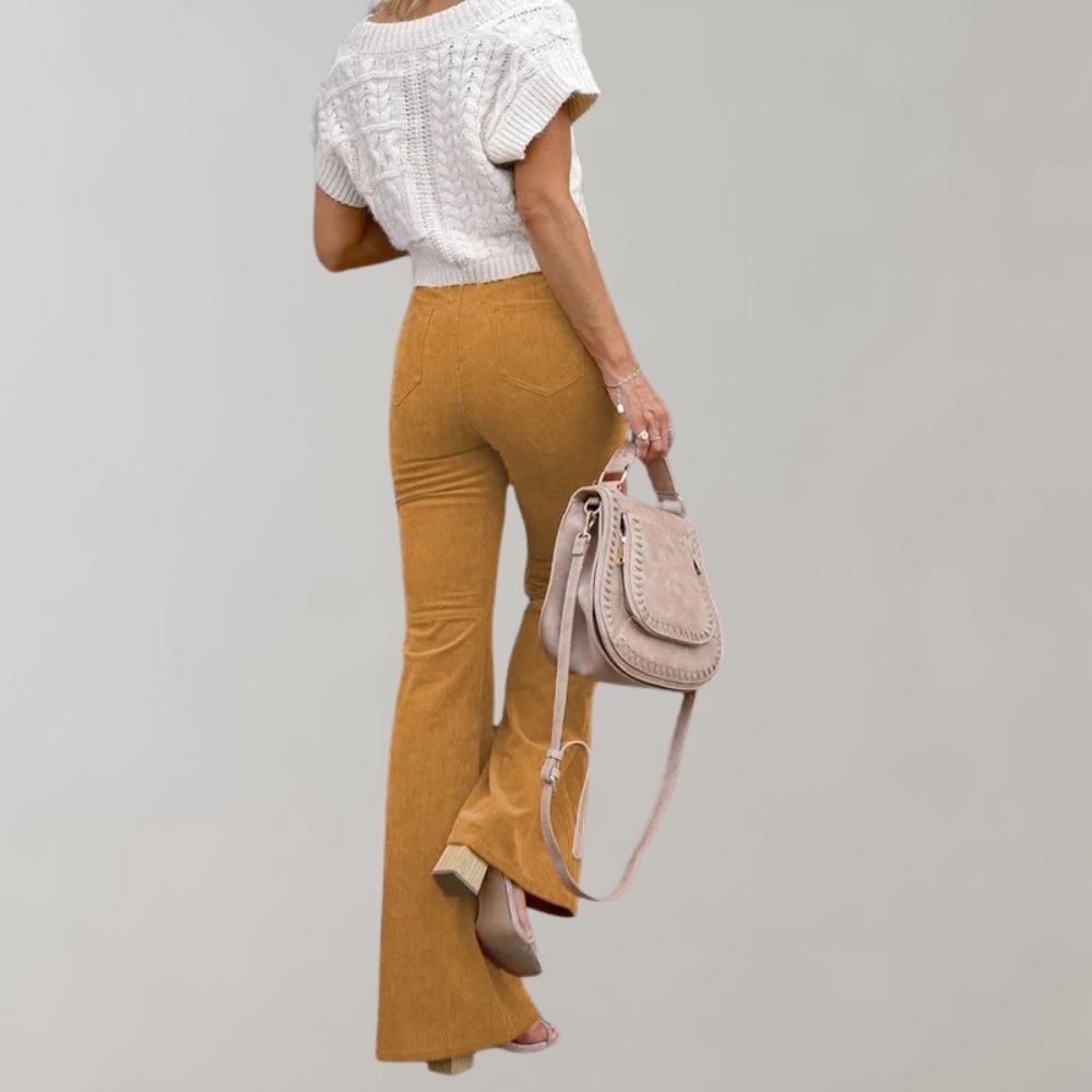 A woman modeling high-waisted flared pants paired with a cropped knit top and a stylish handbag, showcasing the chic and versatile design of the Lila | Women's High-Waisted Flared Pants | Chic Corduroy Trousers.