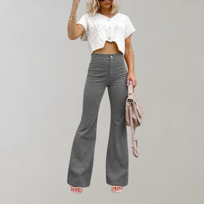 A woman modeling high-waisted flared pants paired with a cropped knit top and a stylish handbag, showcasing the chic and versatile design of the Lila | Women's High-Waisted Flared Pants | Chic Corduroy Trousers.