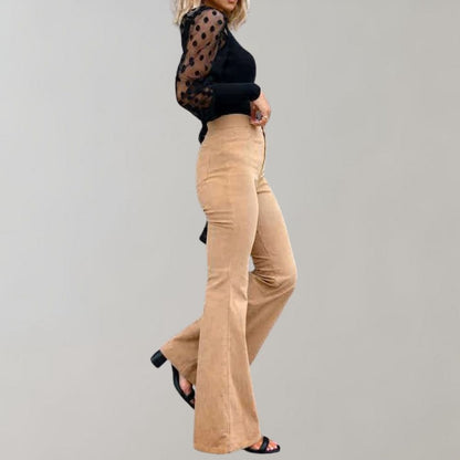 A woman modeling high-waisted flared pants paired with a cropped knit top and a stylish handbag, showcasing the chic and versatile design of the Lila | Women's High-Waisted Flared Pants | Chic Corduroy Trousers.