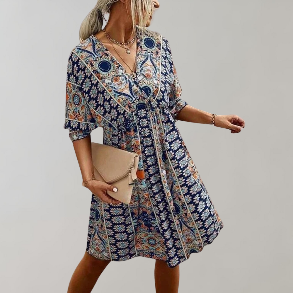 Woman wearing a bohemian-style dress with a flowy fit, featuring intricate patterns and a casual, elegant design.