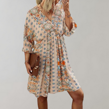 Woman wearing a bohemian-style dress with a flowy fit, featuring intricate patterns and a casual, elegant design.