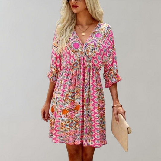 Woman wearing a bohemian-style dress with a flowy fit, featuring intricate patterns and a casual, elegant design.