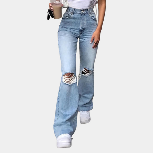 A stylish pair of high-waisted flared jeans featuring a distressed design on the knees, paired with a cropped top and casual sneakers, ideal for a chic and modern casual look.