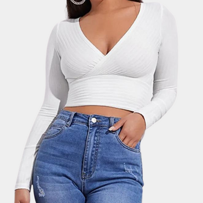 Model wearing the Ava | Long Sleeve Wrap Crop Top, featuring a flattering wrap design and long sleeves. Perfect for pairing with high-waisted pants or skirts, this versatile crop top offers a chic and comfortable look for any occasion.