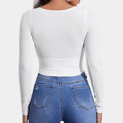 Model wearing the Ava | Long Sleeve Wrap Crop Top, featuring a flattering wrap design and long sleeves. Perfect for pairing with high-waisted pants or skirts, this versatile crop top offers a chic and comfortable look for any occasion.