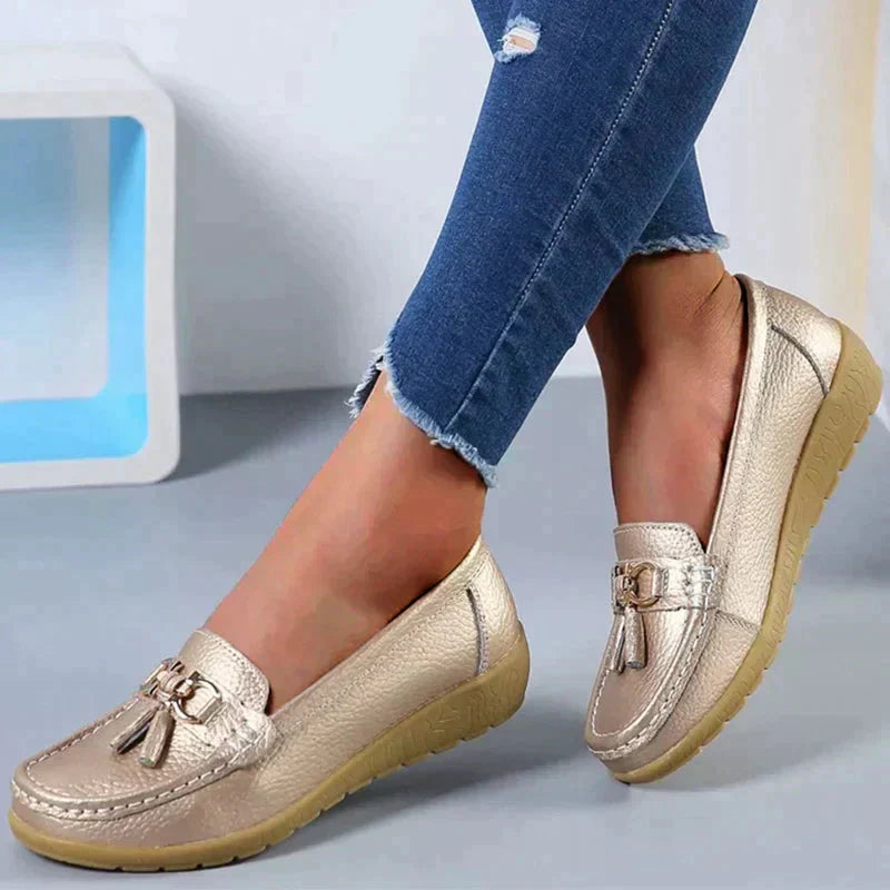 A pair of Grace Women's Classic Loafer Shoes featuring a stylish buckle detail and stitched accents, worn by a person. These loafers combine elegance with comfort, making them suitable for both casual and professional wear.