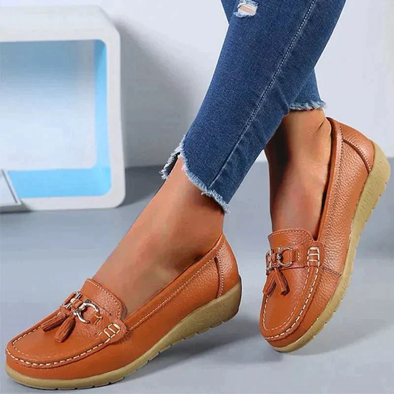 A pair of Grace Women's Classic Loafer Shoes featuring a stylish buckle detail and stitched accents, worn by a person. These loafers combine elegance with comfort, making them suitable for both casual and professional wear.