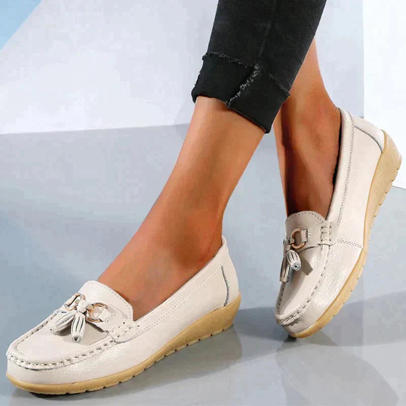 A pair of Grace Women's Classic Loafer Shoes featuring a stylish buckle detail and stitched accents, worn by a person. These loafers combine elegance with comfort, making them suitable for both casual and professional wear.