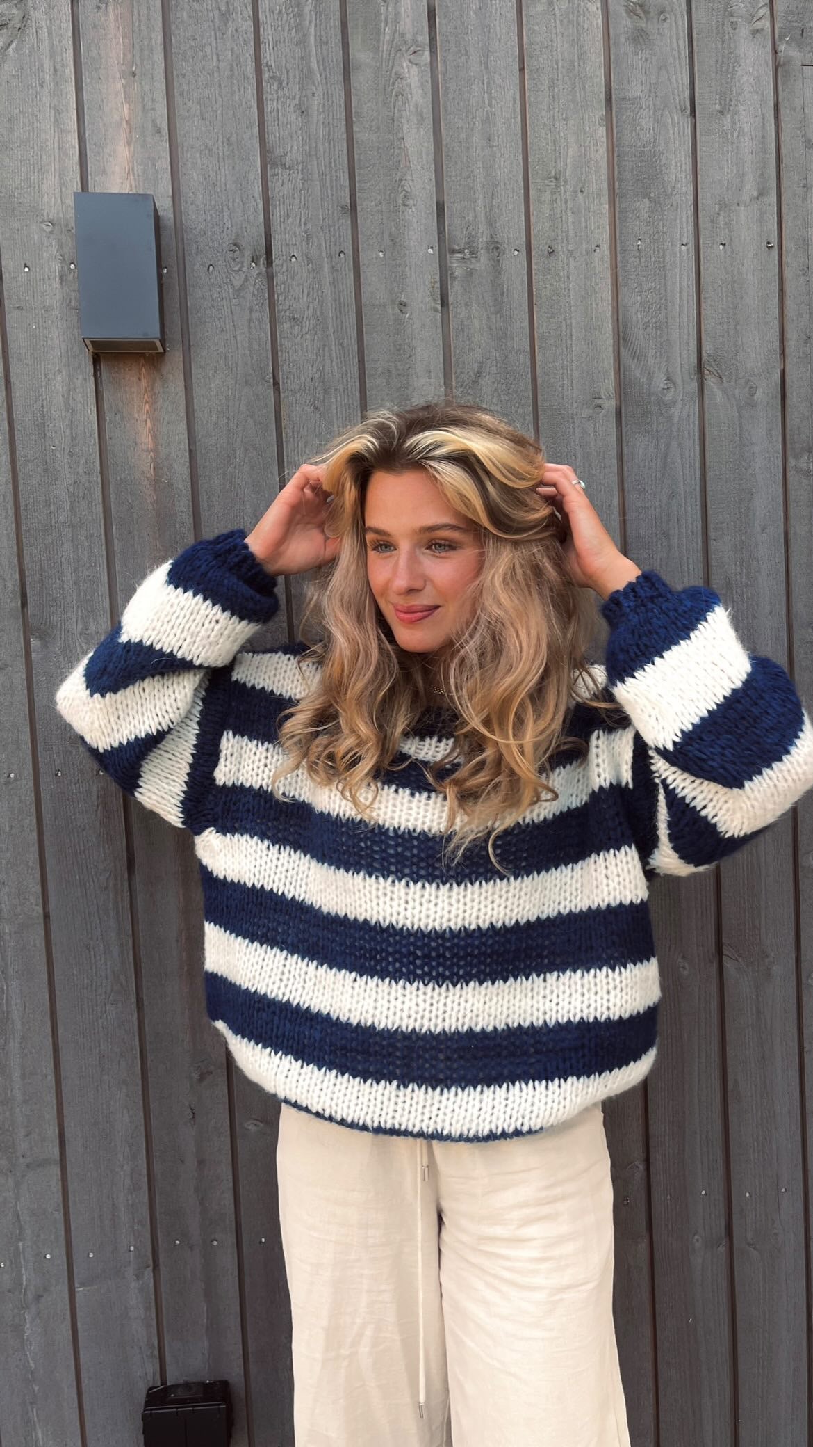 Model wearing the Sophia | Striped Knit Sweater, featuring bold stripes and a cozy, relaxed fit. Perfect for layering or wearing on its own, this sweater adds a touch of casual style to any outfit while keeping you warm and comfortable.