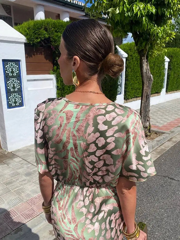 A woman wearing the Livia Women's Elegant Wrap Dress, featuring a luxurious wrap design with flowing short sleeves and a flattering silhouette. This luxe dress is perfect for upscale events or formal gatherings, showcasing sophisticated elegance and effortless style.