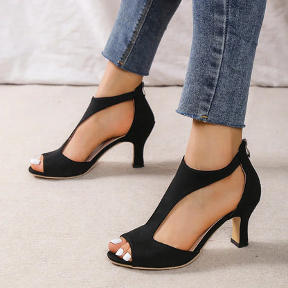 A pair of Sophia Women's Elegant Peep-Toe Heels with a stylish cut-out design, worn by a person. These heels feature a chic peep-toe style and mid-height heel, showcasing an elegant and fashionable look suitable for formal or special occasions.