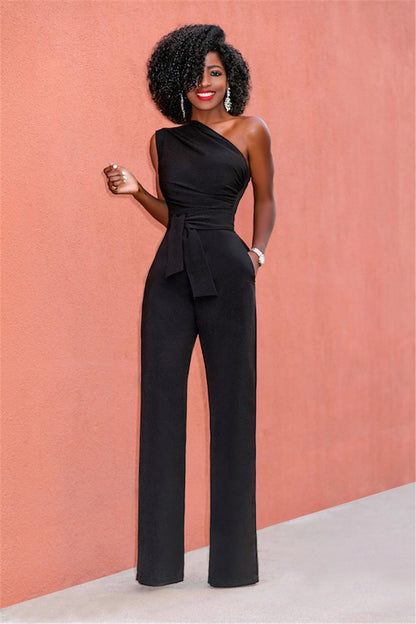 A woman wearing a stylish one-shoulder jumpsuit with a tie waist and wide-leg design, creating an elegant and modern look. The outfit is perfect for formal occasions or evening events, combining sophistication with a bold fashion statement.