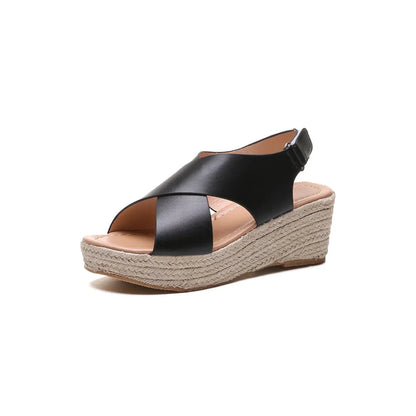 A close-up of a pair of Elena Women's Elegant Wedge Sandals being worn, featuring a stylish cross-strap design and a comfortable wedge sole. These sandals offer a blend of elegance and comfort, ideal for casual or dressy occasions.