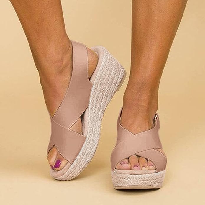 A close-up of a pair of Elena Women's Elegant Wedge Sandals being worn, featuring a stylish cross-strap design and a comfortable wedge sole. These sandals offer a blend of elegance and comfort, ideal for casual or dressy occasions.