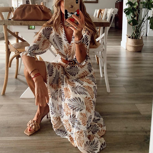 Model wearing the Elena Women's Leaf Print Dress, a flowing belted dress with nature-inspired leaf patterns, perfect for casual and semi-formal occasions.