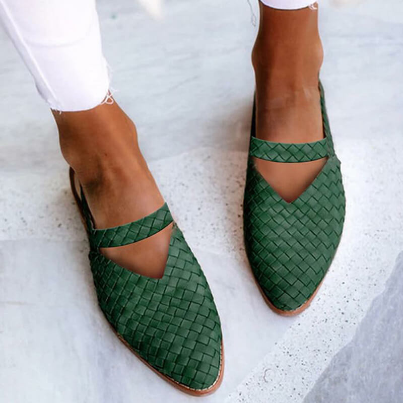 Close-up of a pair of woven slip-on sandals worn with rolled-up pants, showcasing a stylish V-shaped cutout design and casual elegance for effortless, everyday wear.