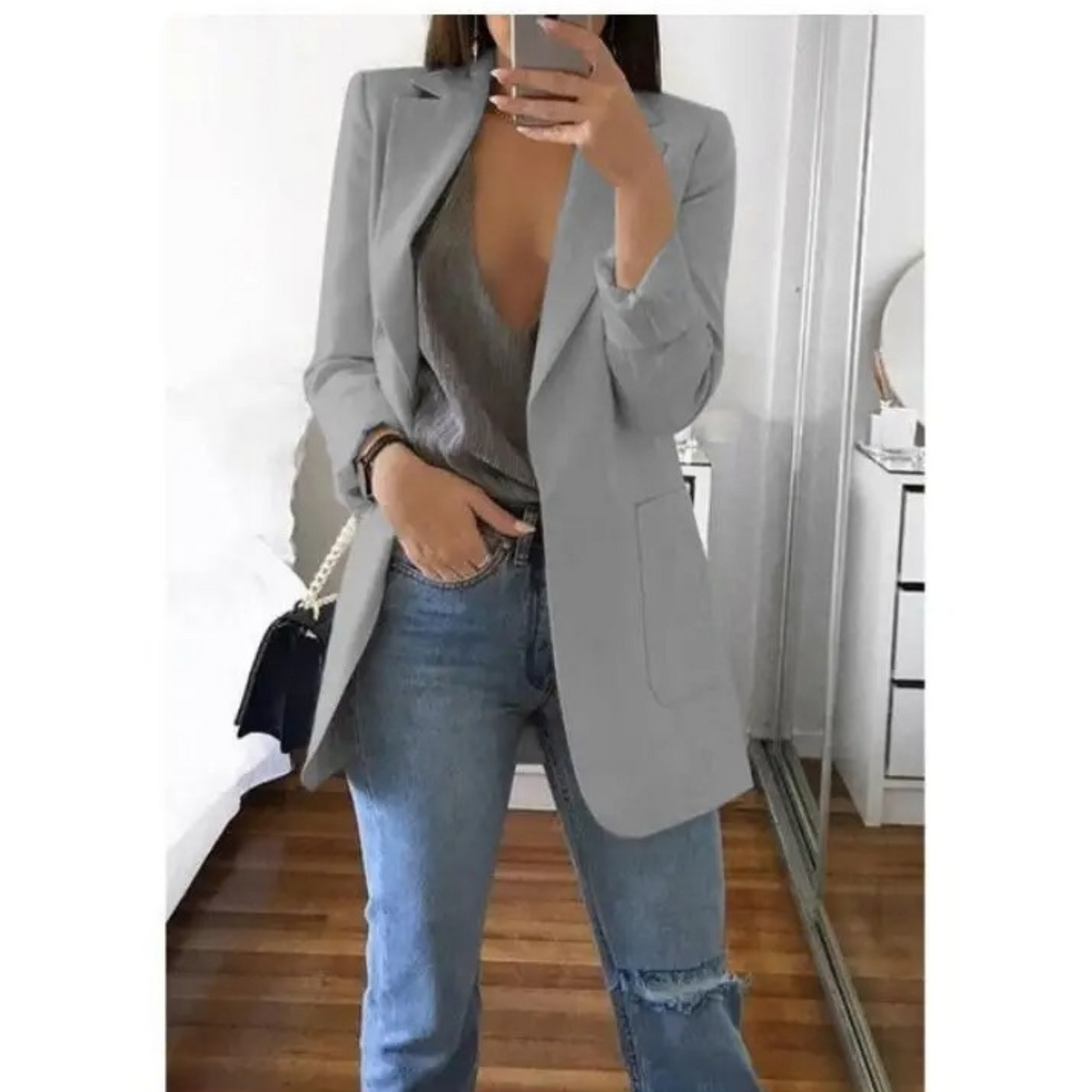 Femme portant le blazer long élégant Elodie pour femme, avec une coupe structurée et épurée. Le blazer est associé à un top et un jean, créant un look chic et décontracté, parfait pour le bureau ou une sortie.