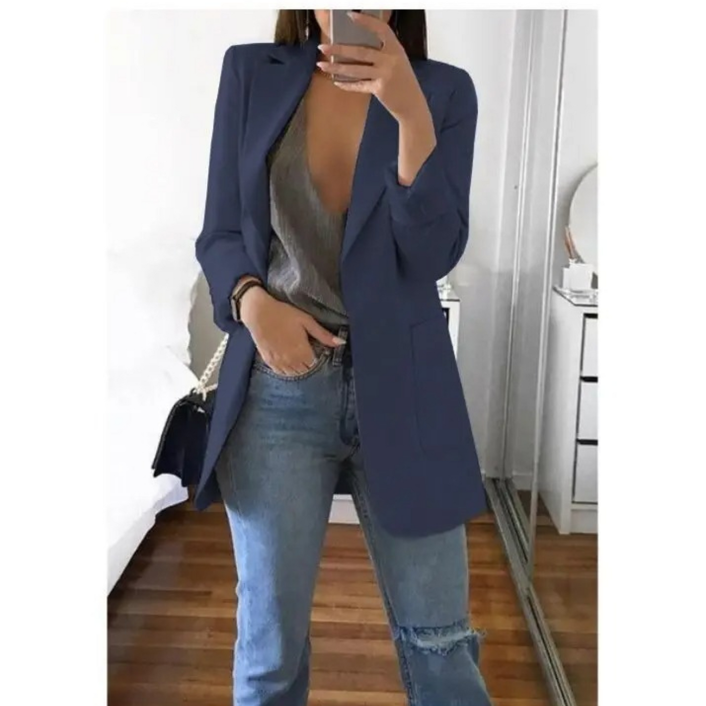 Femme portant le blazer long élégant Elodie pour femme, avec une coupe structurée et épurée. Le blazer est associé à un top et un jean, créant un look chic et décontracté, parfait pour le bureau ou une sortie.