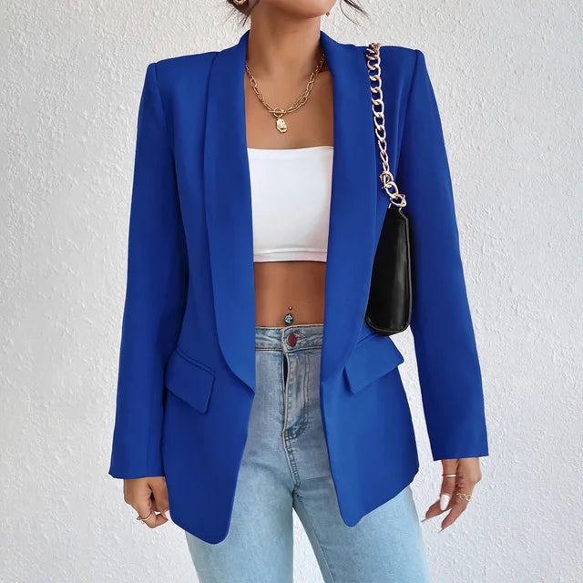 A woman wearing a stylish tailored blazer over a crop top and high-waisted jeans, creating a chic and modern look. The blazer features a structured fit with pockets, adding sophistication to the casual outfit. Perfect for elevating any ensemble with a touch of elegance.