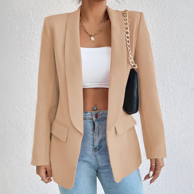 A woman wearing a stylish tailored blazer over a crop top and high-waisted jeans, creating a chic and modern look. The blazer features a structured fit with pockets, adding sophistication to the casual outfit. Perfect for elevating any ensemble with a touch of elegance.