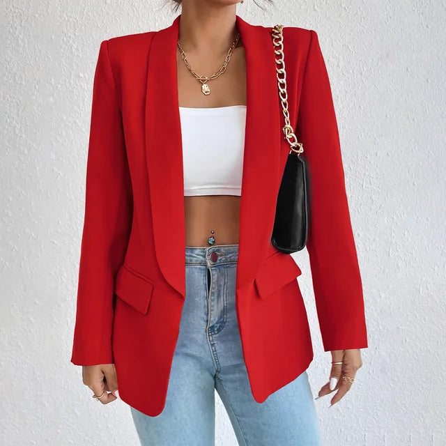 A woman wearing a stylish tailored blazer over a crop top and high-waisted jeans, creating a chic and modern look. The blazer features a structured fit with pockets, adding sophistication to the casual outfit. Perfect for elevating any ensemble with a touch of elegance.