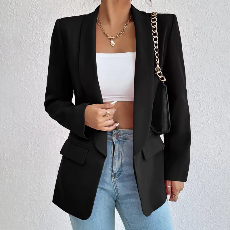 A woman wearing a stylish tailored blazer over a crop top and high-waisted jeans, creating a chic and modern look. The blazer features a structured fit with pockets, adding sophistication to the casual outfit. Perfect for elevating any ensemble with a touch of elegance.