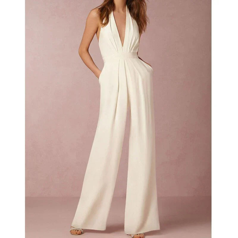 Model wearing the Bella | Plunging Halter Jumpsuit featuring a deep neckline, fitted waist, and flowing wide-leg silhouette, perfect for making a bold fashion statement at formal events or special occasions.