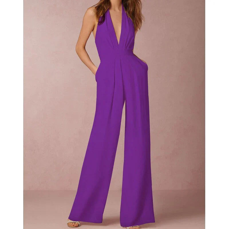 Model wearing the Bella | Plunging Halter Jumpsuit featuring a deep neckline, fitted waist, and flowing wide-leg silhouette, perfect for making a bold fashion statement at formal events or special occasions.