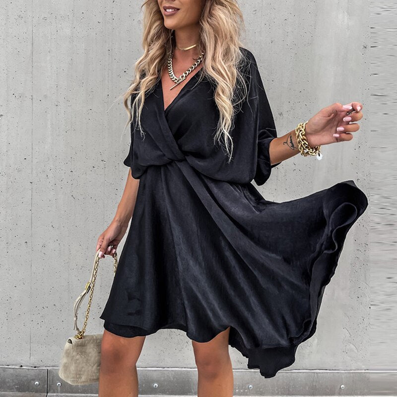 A stylish woman wearing the Lila Women's Flowy Wrap Dress with a flattering wrap design and flowing fabric, accessorized with jewelry and a chic handbag, perfect for an elegant evening look.