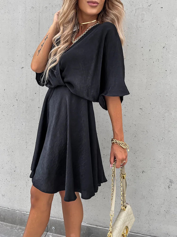 A stylish woman wearing the Lila Women's Flowy Wrap Dress with a flattering wrap design and flowing fabric, accessorized with jewelry and a chic handbag, perfect for an elegant evening look.