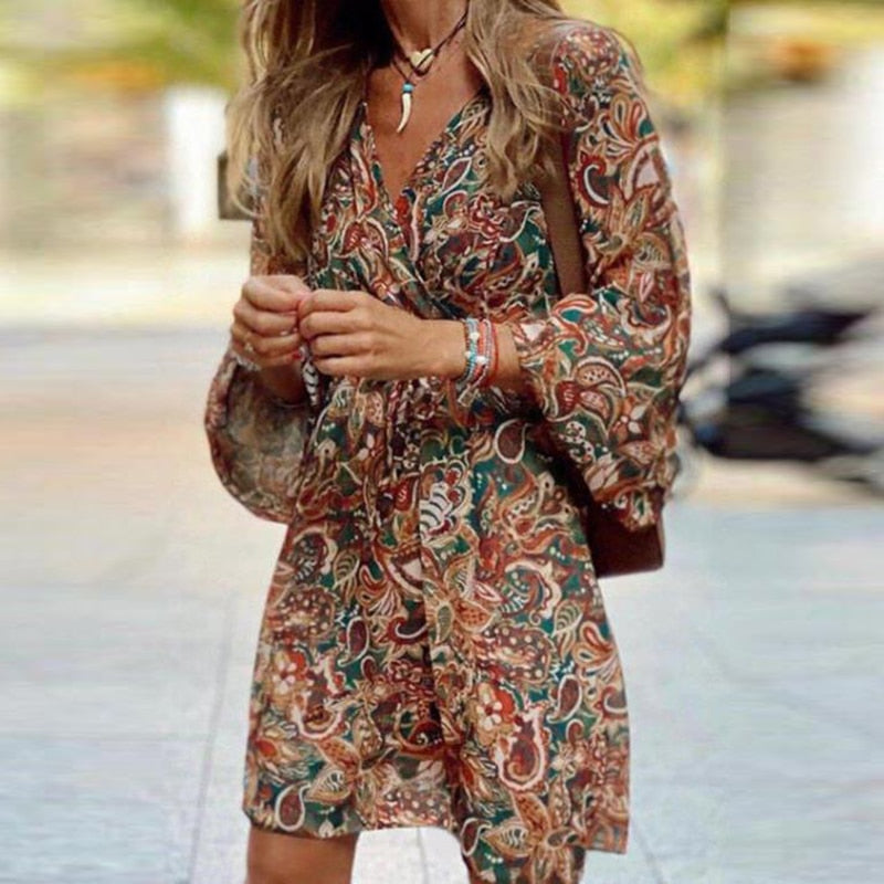 Model wearing the Esme Women's Boho Mini Dress with flowing sleeves and intricate paisley patterns, perfect for a chic, bohemian look. The dress offers a relaxed fit, ideal for casual outings or warm-weather events, styled with a crossbody bag and delicate accessories.