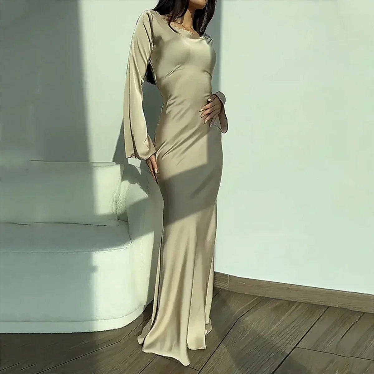 A woman gracefully modeling the Sophia | Women's Elegant Maxi Dress | Flowy Evening Gown, showcasing its sophisticated and flowing design, perfect for formal events or special occasions. The dress features long sleeves and a fitted silhouette that exudes elegance and charm.